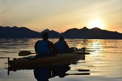 Kveldspadling er en fantastisk opplevelse der du får oppleve solnedgang eller midnattsol i kajakk. Foto: Lofoten Kayak.