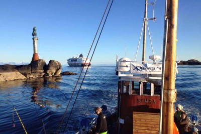 Symra på tur inn på havna i Svolvær etter fisketur med Fiskekona og hurtigruta i bakgrunnen. Foto: Øystein Omdal.