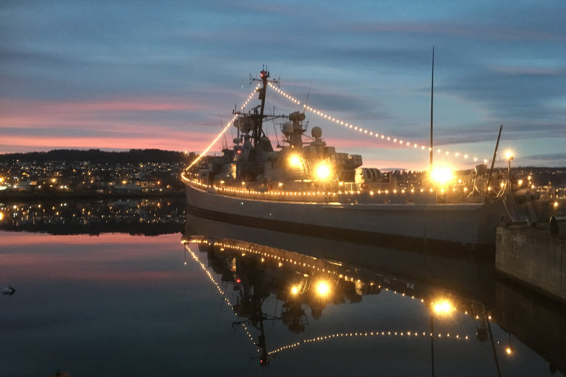 KNM Narvik pyntet til fest i skumringen. Foto: KNM Narvik.